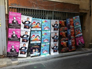 Un mur d'affiches au festival d'Avignon 2015 pour les spectacles de George Sand, Piano Rigoletto, Camille et les Maisons Magiques, Monsieur Fraize, Coming Out