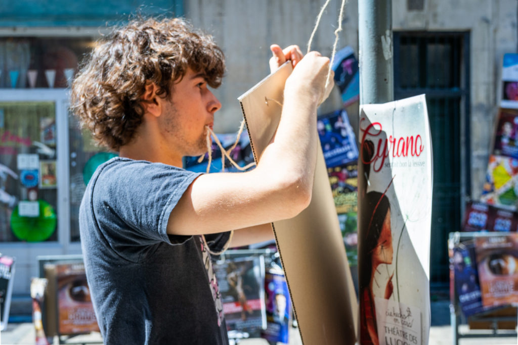 Affichage d’un support rigide avec une ficelle au festival d’Avignon 2018.